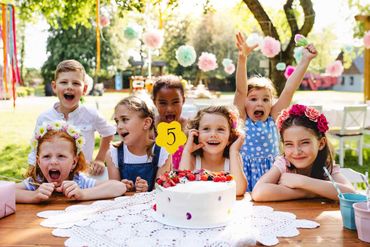 enfants dehors devant un gateau d'anniversaire